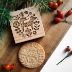 róka és virágok mintás kerek mézeskalács és fából készült kekszpecsét, fa deszkán, fenyőággal, csipkebogyóval