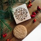rénszarvas skandináv mintás kerek mézeskalács és fából készült kekszpecsét ezzel a mintával, mindez fa deszkán, fenyőággal, csipkebogyóval
